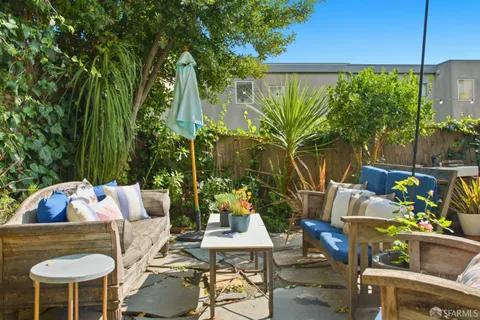 a view of a patio with couches table and chairs and potted plants