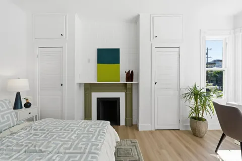 a bedroom with a bed and a potted plant