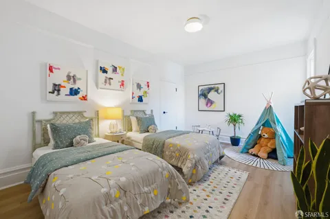 a bedroom with two beds and painting on the wall