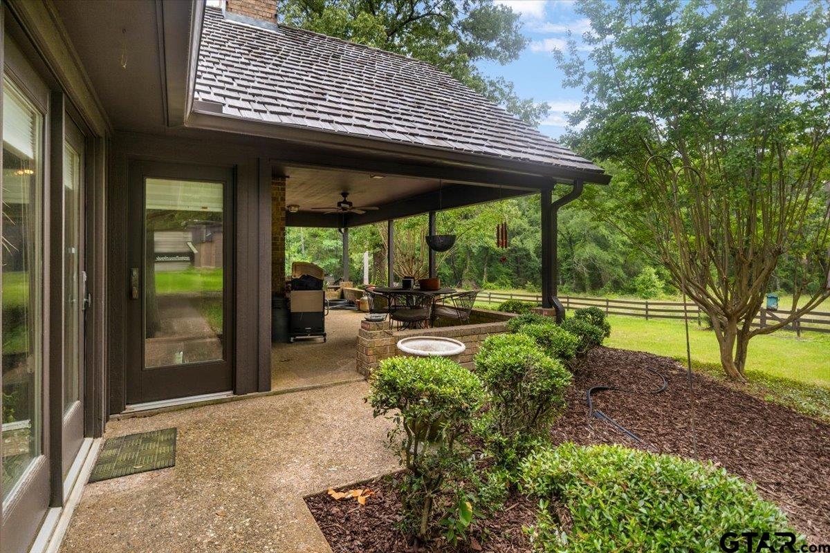 15246 7 League Road Tyler, TX 75703 - Photo 35 of 43 a view of a patio with table and chairs under an umbrella