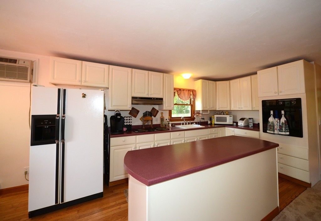 124 Sherbert Road Ashburnham, MA 01430 - Photo 7 of 27 a kitchen with stainless steel appliances granite countertop a refrigerator a sink dishwasher a stove and white countertops with wooden floor