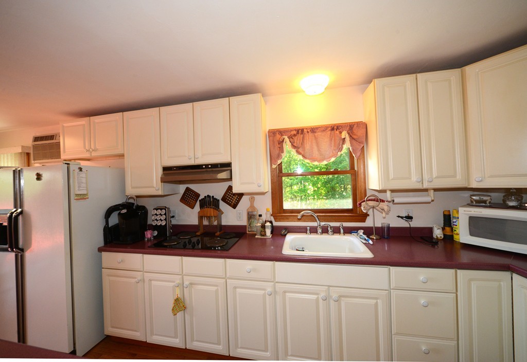 124 Sherbert Road Ashburnham, MA 01430 - Photo 9 of 27 a kitchen with a sink cabinets and a window