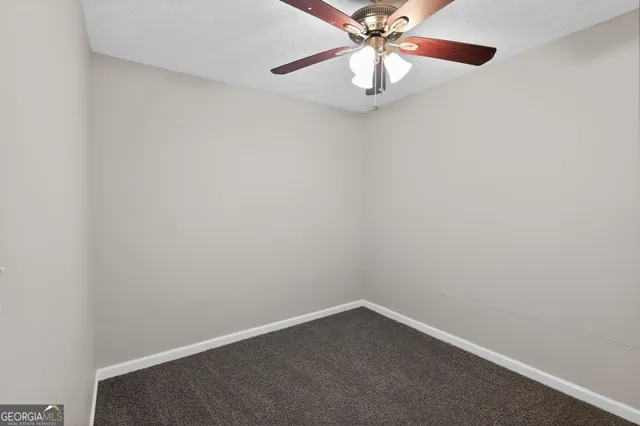 an empty room with a chandelier fan