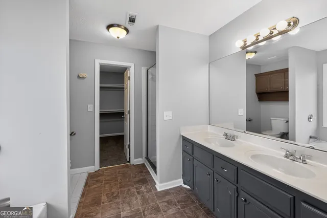 a spacious bathroom with a double vanity sink and a mirror