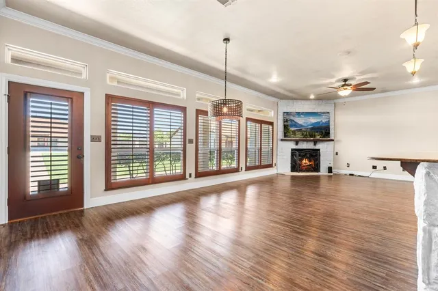 a view of a kitchen with kitchen island a sink wooden floor and stainless steel appliances