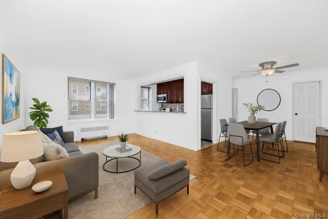 a living room with furniture kitchen view and a window
