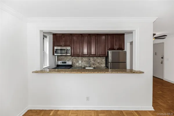 a kitchen with stainless steel appliances granite countertop a refrigerator a stove and a wooden cabinets