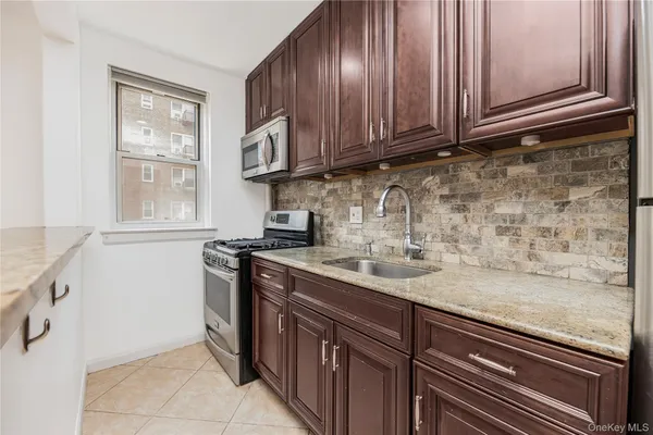 a kitchen with stainless steel appliances granite countertop a sink stove and cabinets