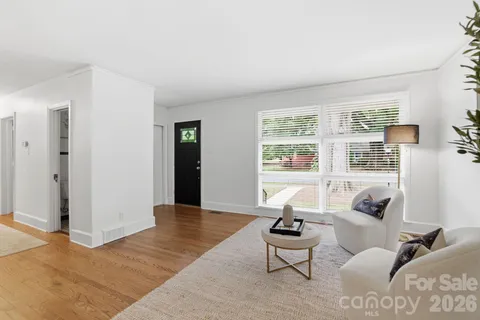 a living room with furniture and floor to ceiling windows