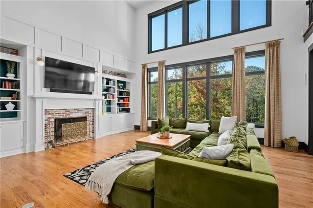 a bedroom with a bed wooden floor and a large window