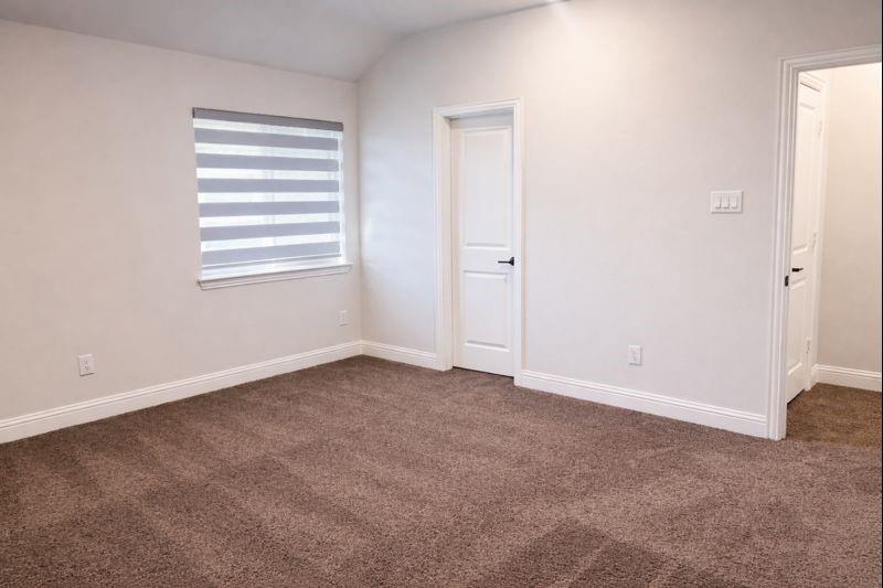 6825 Entwistle Road Frisco, TX 75034 - Photo 21 of 25 This room features light-colored walls, brown carpet, a window with blinds, and white doors with dark hardware