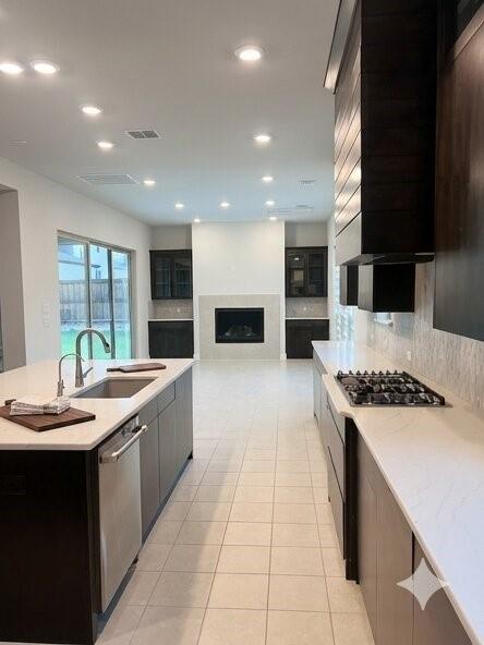 6825 Entwistle Road Frisco, TX 75034 - Photo 5 of 25 The property features a kitchen with an island, a stainless steel sink and faucet, and a gas cooktop