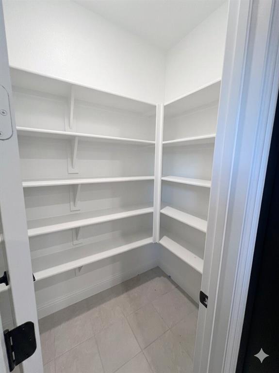 6825 Entwistle Road Frisco, TX 75034 - Photo 7 of 25 Spacious pantry featuring extensive white shelving and light-colored tile flooring