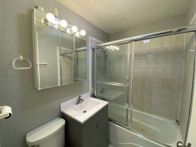 a bathroom with a toilet sink and mirror
