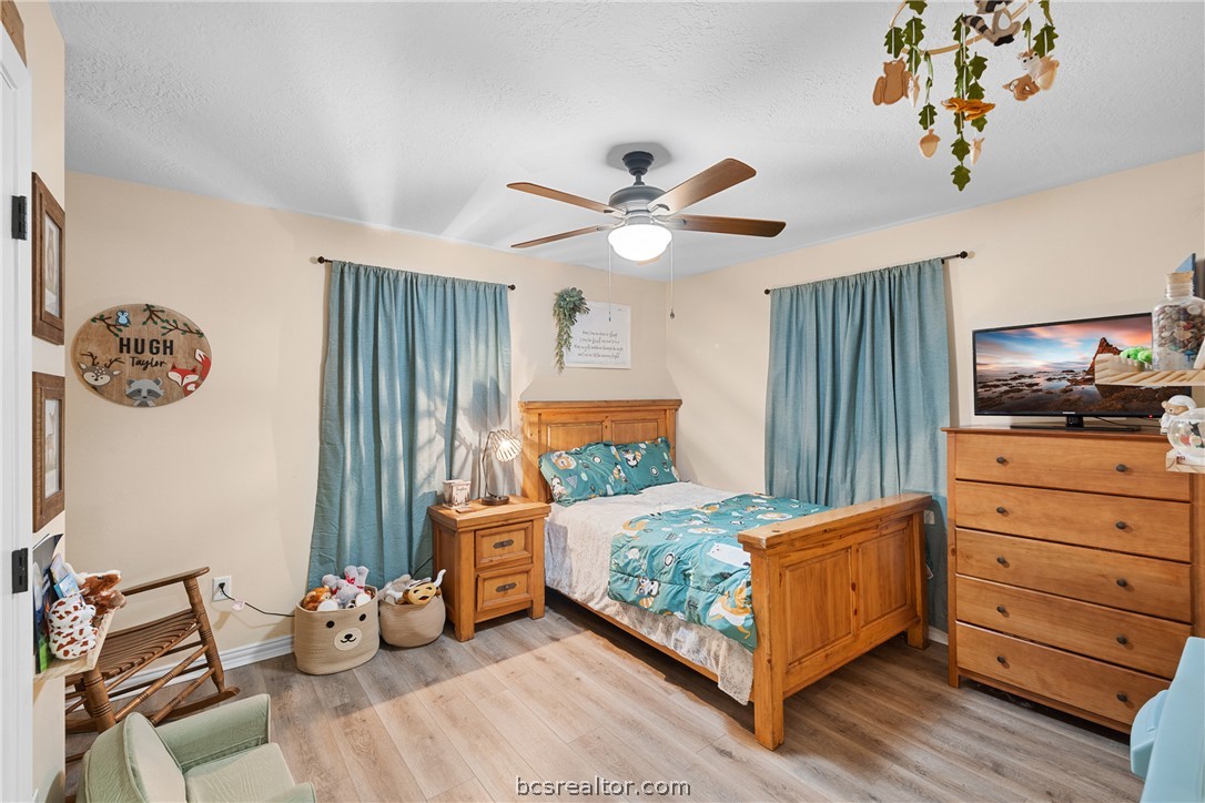 3540 Fisher Ranch Road Bryan, TX 77808 - Photo 17 of 36 a bedroom with a bed and a chandelier