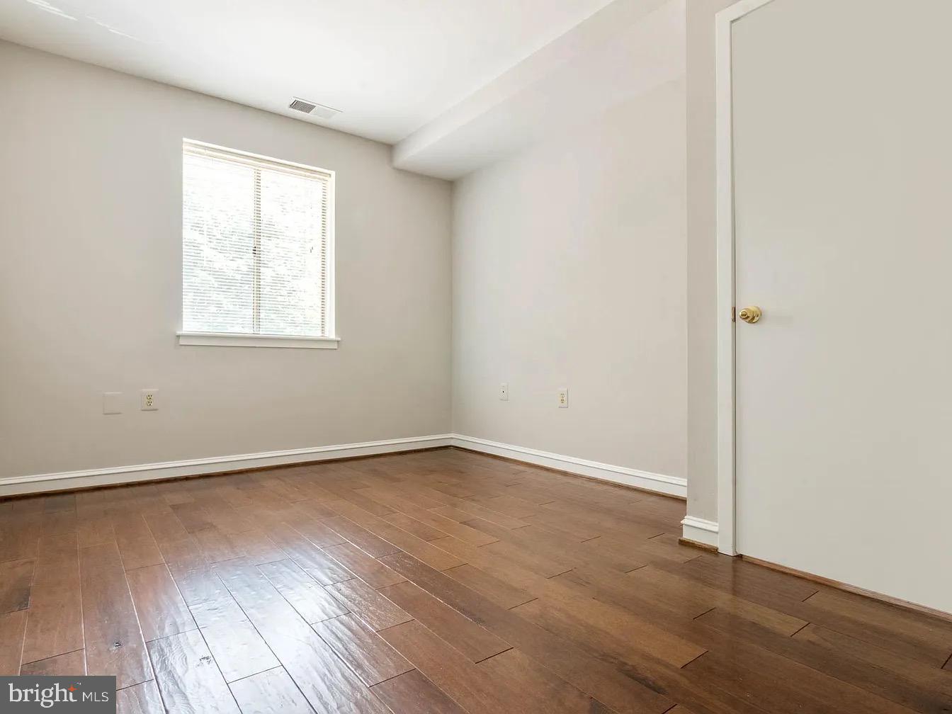 16 Andrew Place Baltimore, MD 21201 - Photo 12 of 17 an empty room with wooden floor and windows
