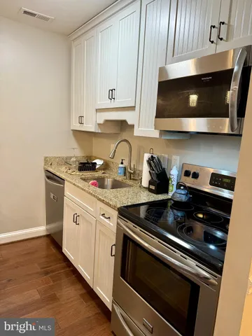 a kitchen with stainless steel appliances granite countertop a stove a microwave and cabinets