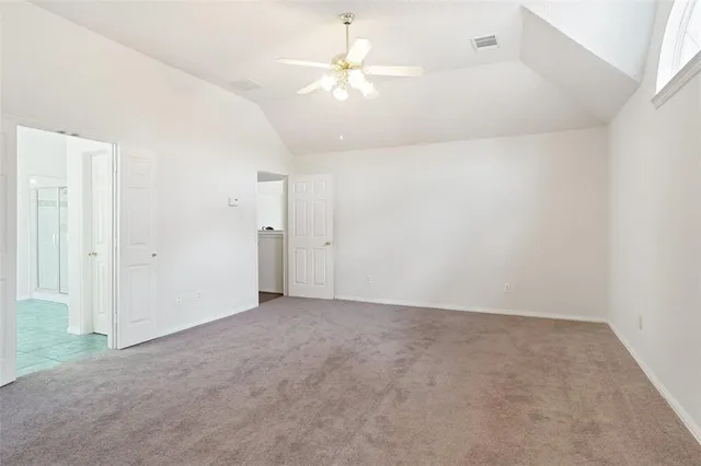 an empty room with a ceiling fan and a window