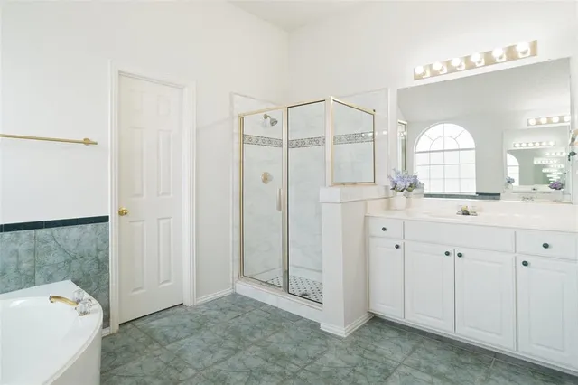 a spacious bathroom with a shower a sink and a mirror