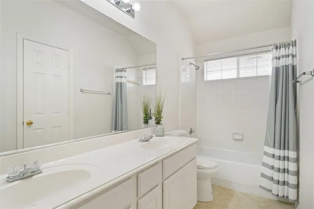 a bathroom with a granite countertop sink a toilet and shower
