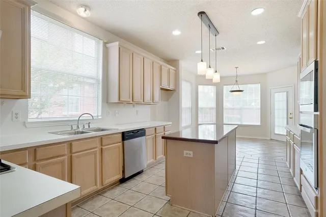 a kitchen with a sink window and cabinets