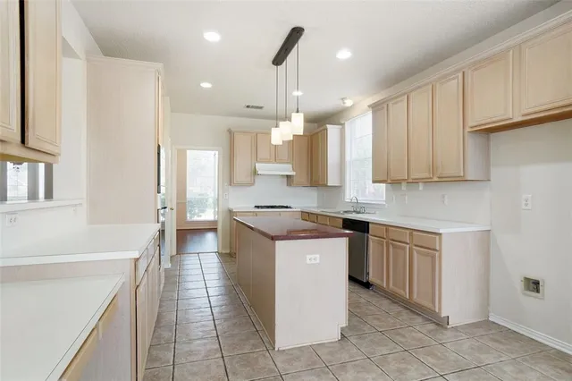 a kitchen with stainless steel appliances granite countertop a sink and a stove