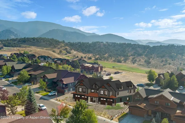 an aerial view of residential houses with outdoor space and river