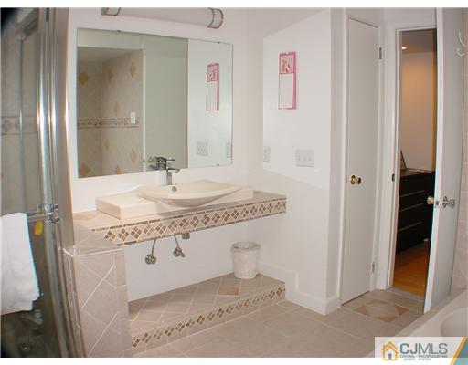4507 Stonehedge Road Edison, NJ 08820 - Photo 8 of 10 a bathroom with a granite countertop sink a mirror and a bathtub