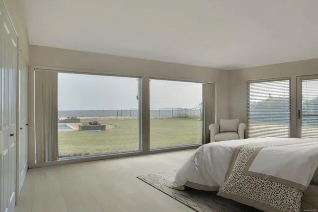 a bedroom with a bed and glass walk in closet