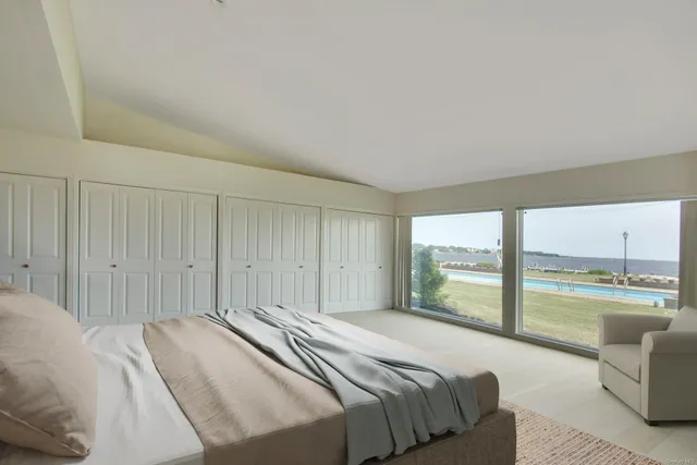 a spacious bedroom with a bed and large windows