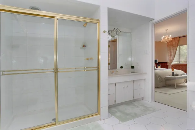 a bathroom with a tub shower and mirror