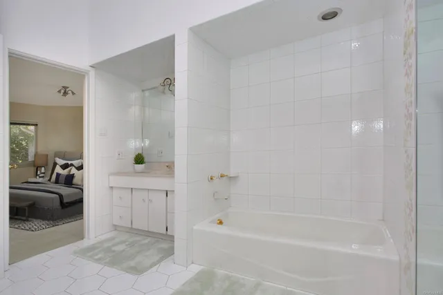 a bed sitting in a spacious bedroom next to a window