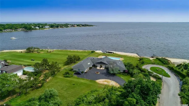 an aerial view of a house with a yard and lake view