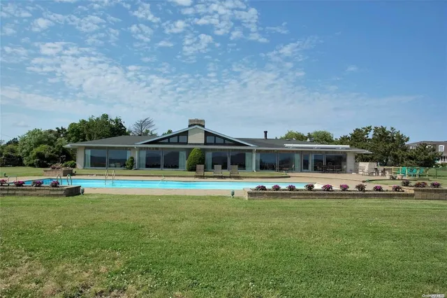 a front view of a house with a garden and trees