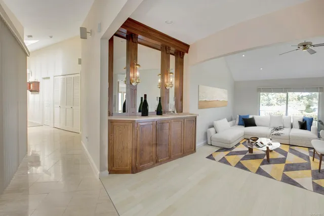 a living room with furniture a large window and wooden floor