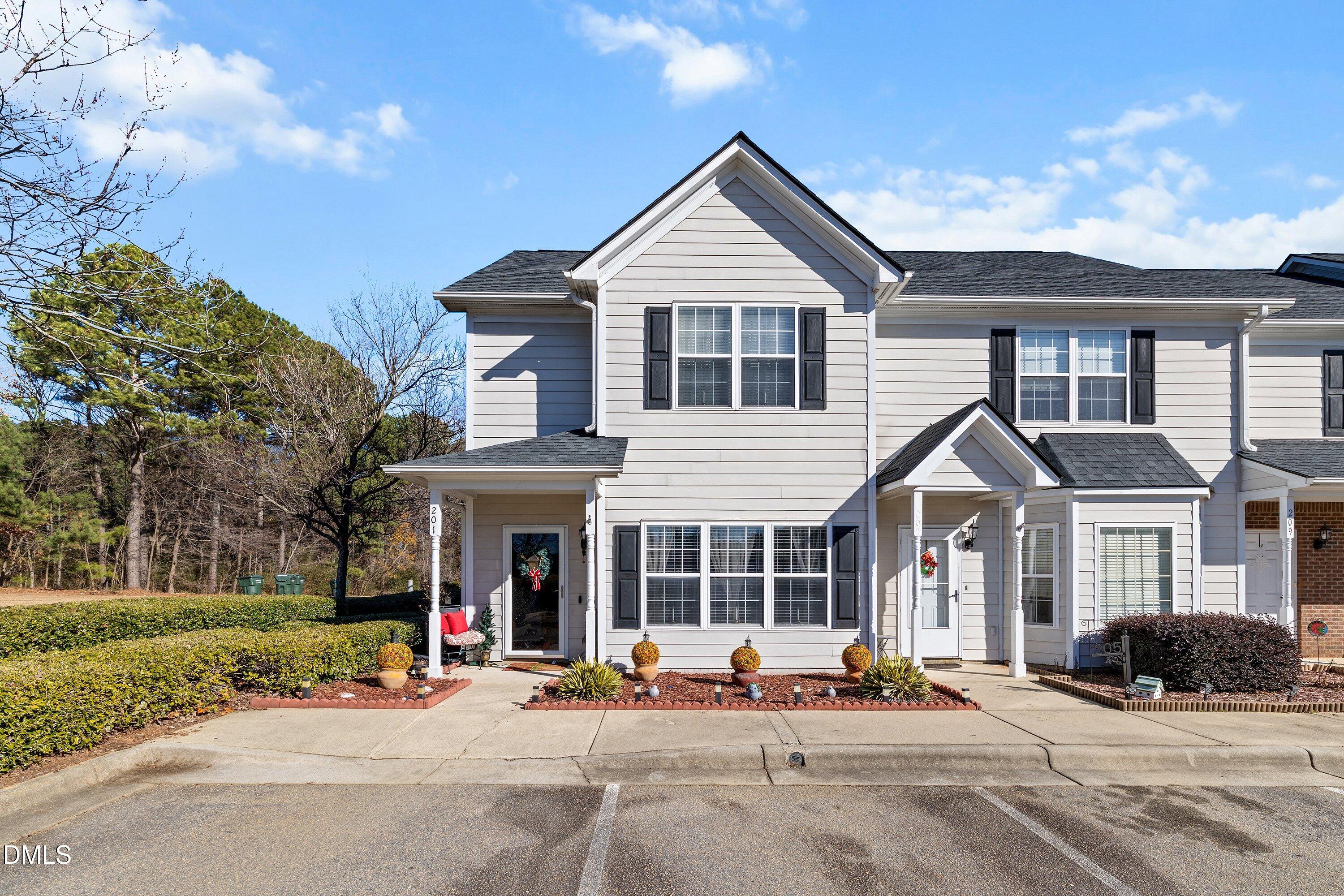 a front view of a house with outdoor seating and a parking space