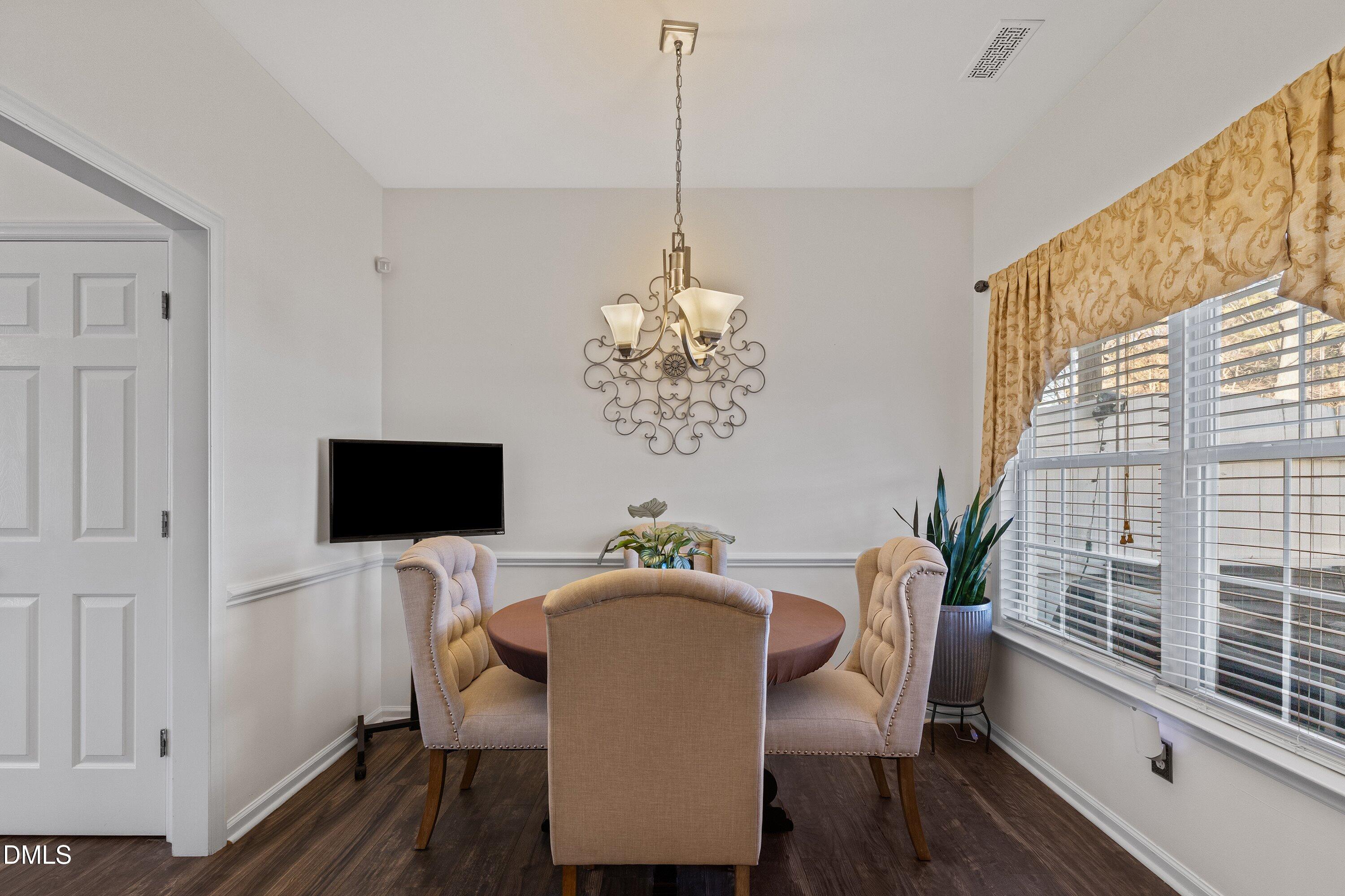 201 Dairy Road Clayton, NC 27520 - Photo 11 of 31 a dining room with furniture a chandelier and wooden floor
