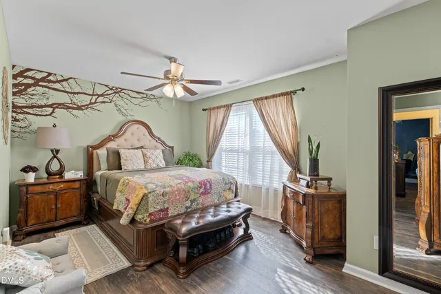 a bedroom with a bed a flat screen tv and a window