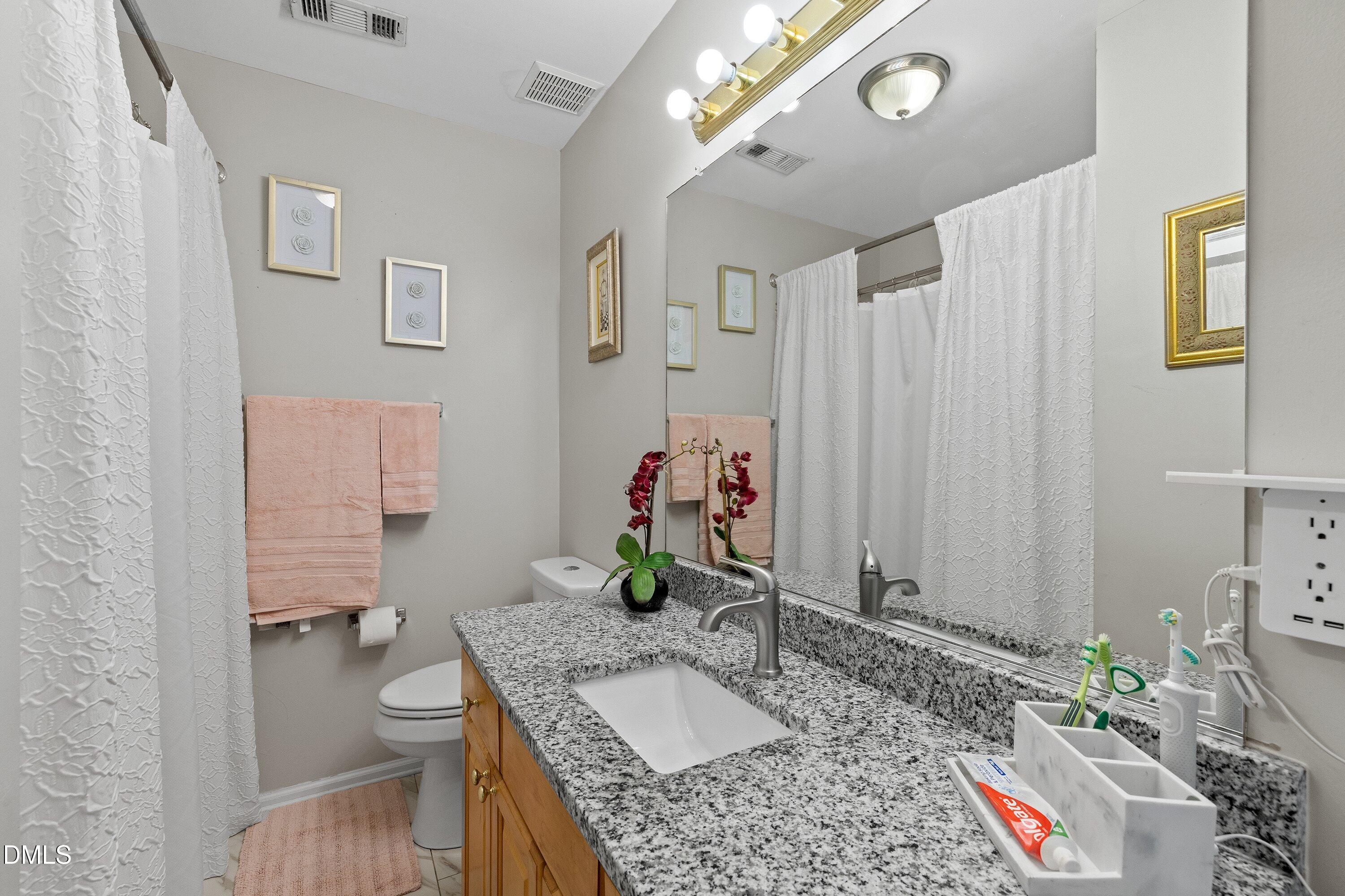 201 Dairy Road Clayton, NC 27520 - Photo 26 of 31 a bathroom with a granite countertop sink and a mirror