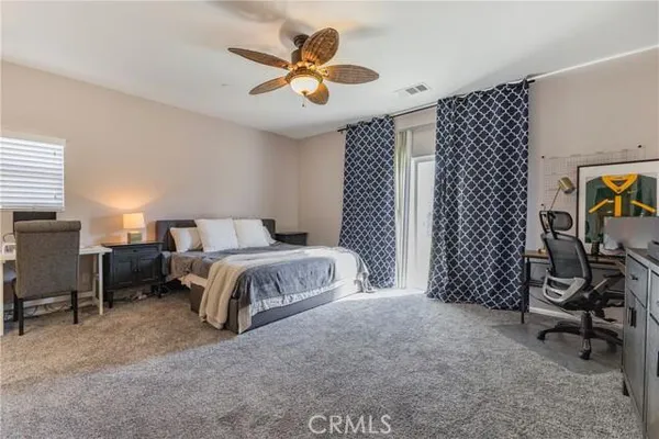 a spacious bedroom with a bed and a chandelier
