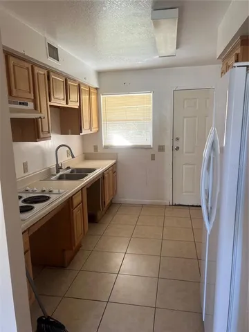 a kitchen with a stove a refrigerator and a sink