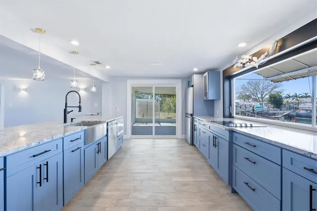 a kitchen with stainless steel appliances granite countertop a sink and a stove