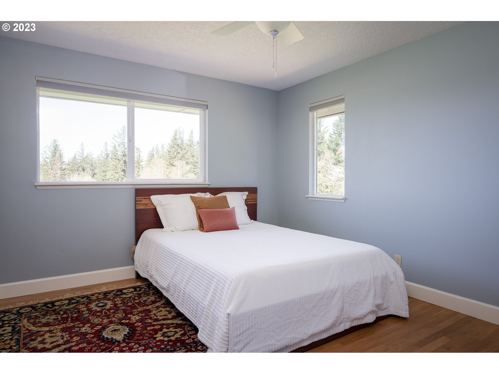 930 Northeast Salzman Road Corbett, OR 97019 - Photo 17 of 32 a bedroom with a large bed and a window