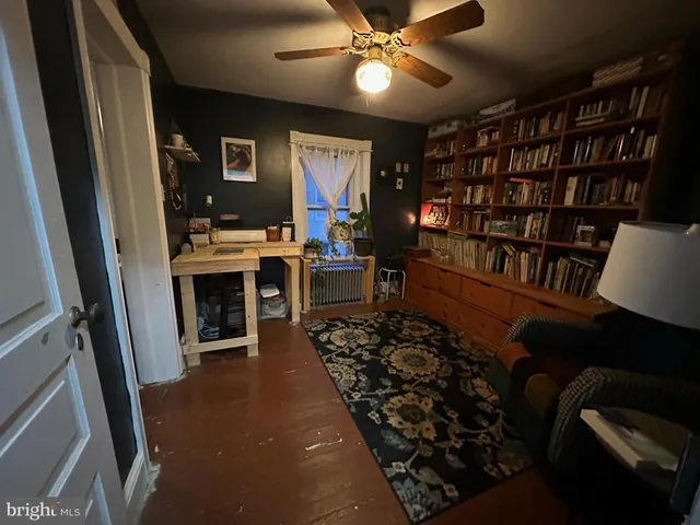a view of a workspace with furniture and a bookshelf