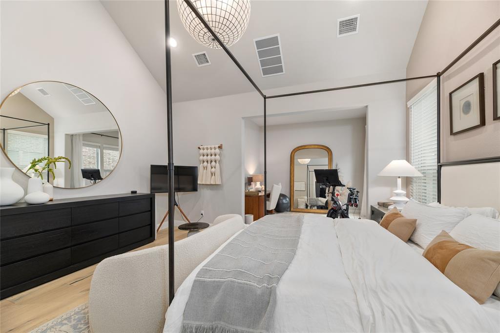2262 Poppyvine Road Frisco, TX 75033 - Photo 18 of 40 This room features light hardwood flooring, a vaulted ceiling, and a prominent dark four-poster bed frame