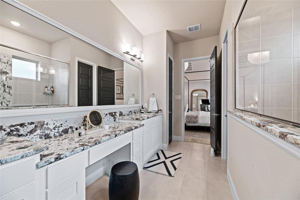 2262 Poppyvine Road Frisco, TX 75033 - Photo 21 of 40 This bathroom features a large vanity with granite countertops, dual sinks, and extensive mirror space