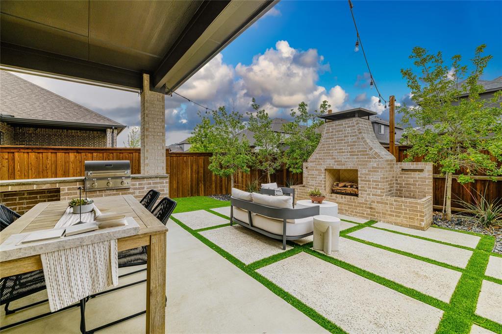 2262 Poppyvine Road Frisco, TX 75033 - Photo 36 of 40 The property features an outdoor patio with a built-in brick fireplace and a separate outdoor cooking station with a grill