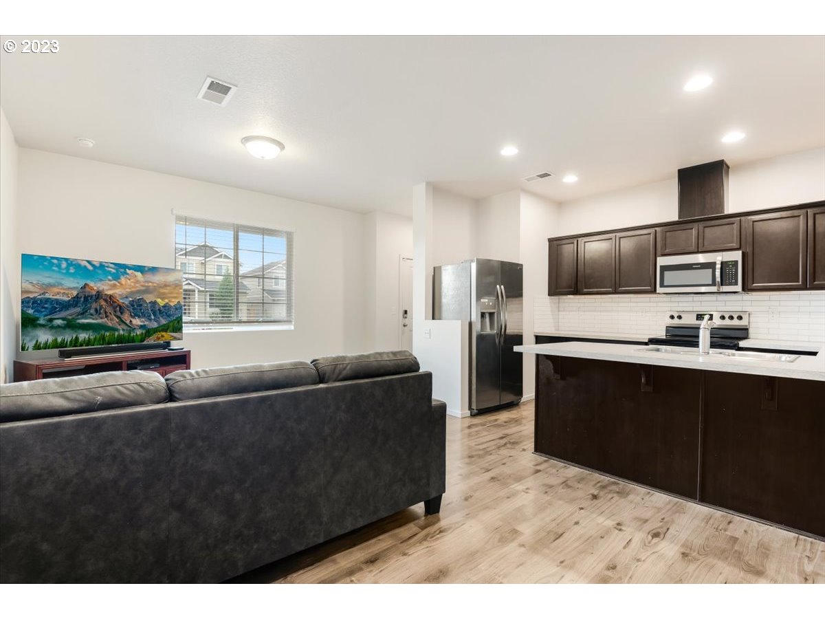 2375 Southeast 16th Street Gresham, OR 97080 - Photo 8 of 28 a living room with stainless steel appliances kitchen island granite countertop a couch and a view of kitchen