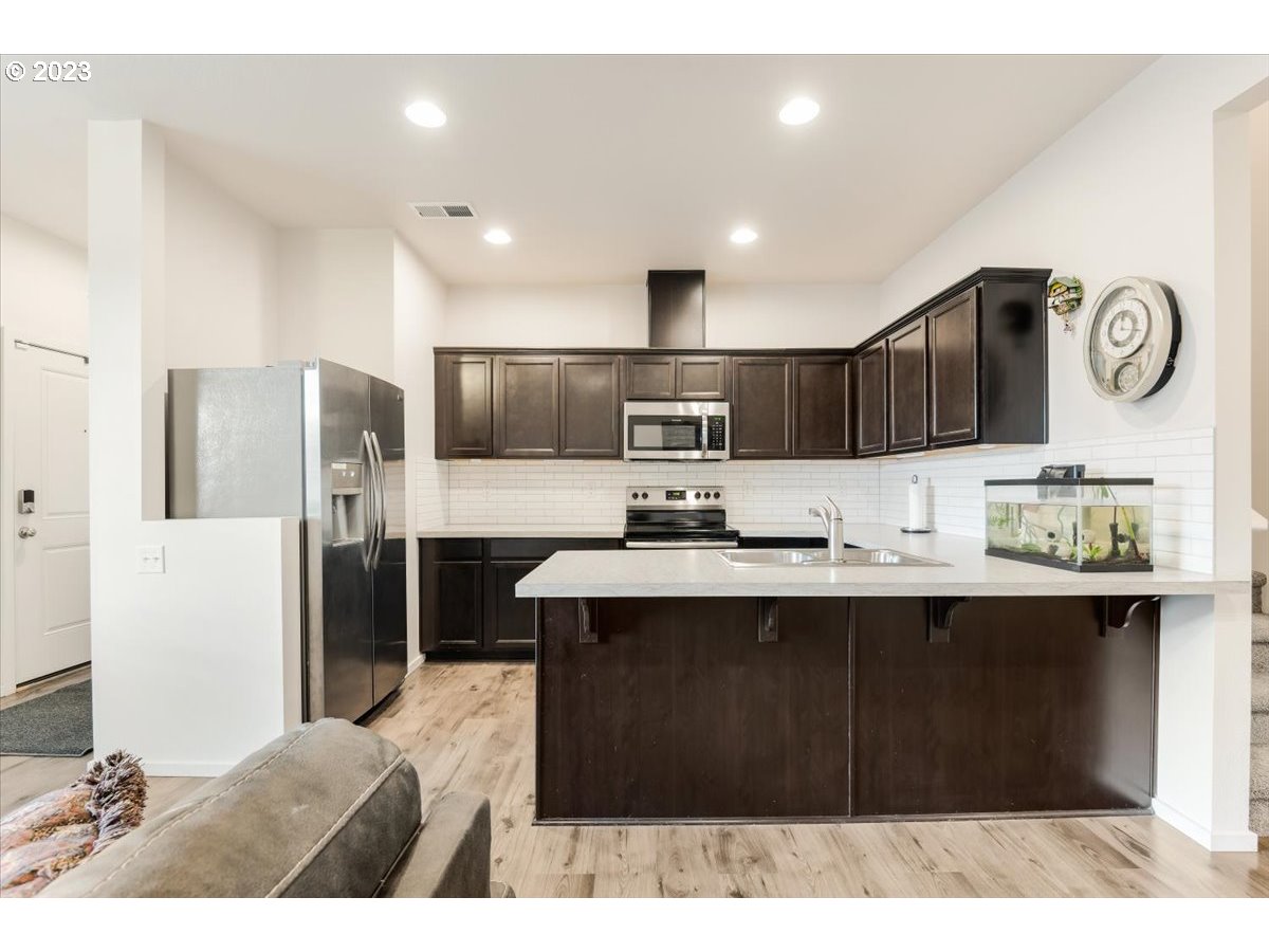 2375 Southeast 16th Street Gresham, OR 97080 - Photo 9 of 28 a kitchen with kitchen island stainless steel appliances a sink and refrigerator
