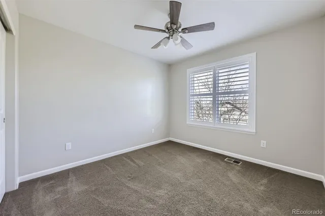an empty room with a window and a fan